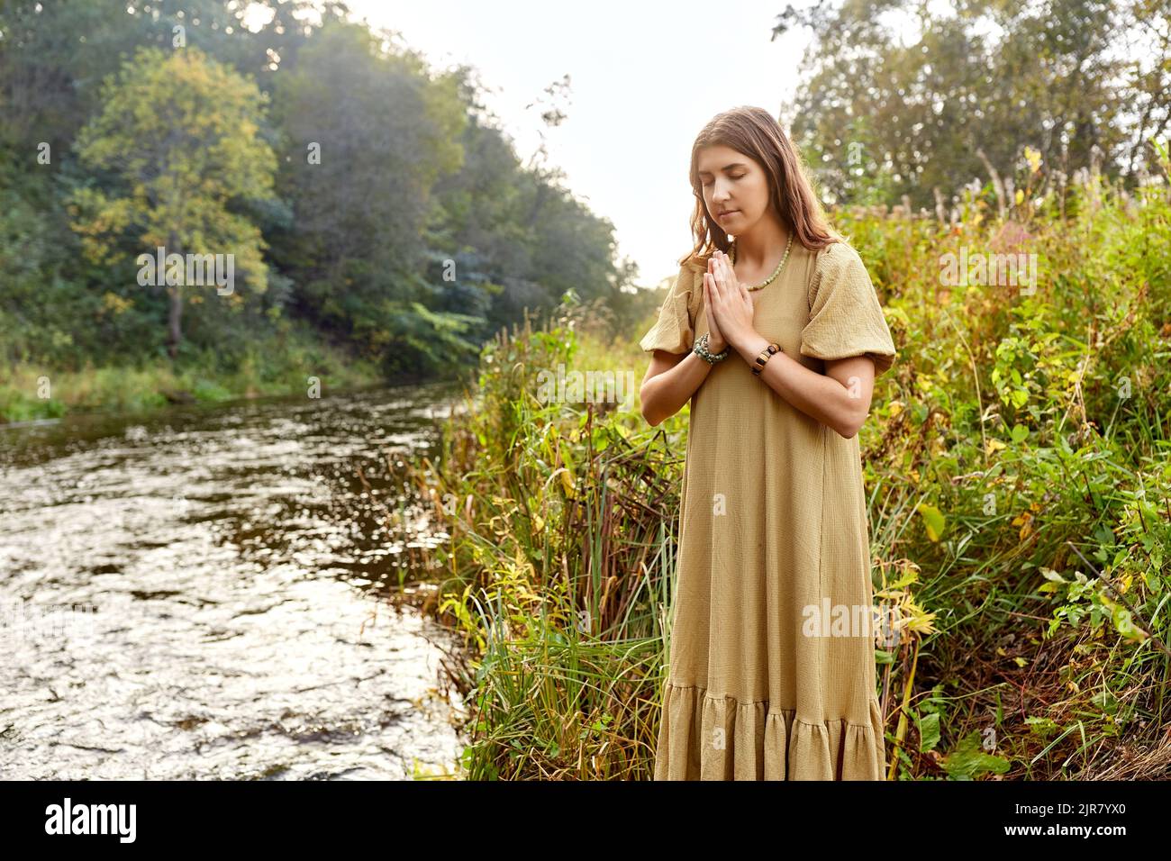 donna o strega che esegue rituale magico sul fiume Foto Stock