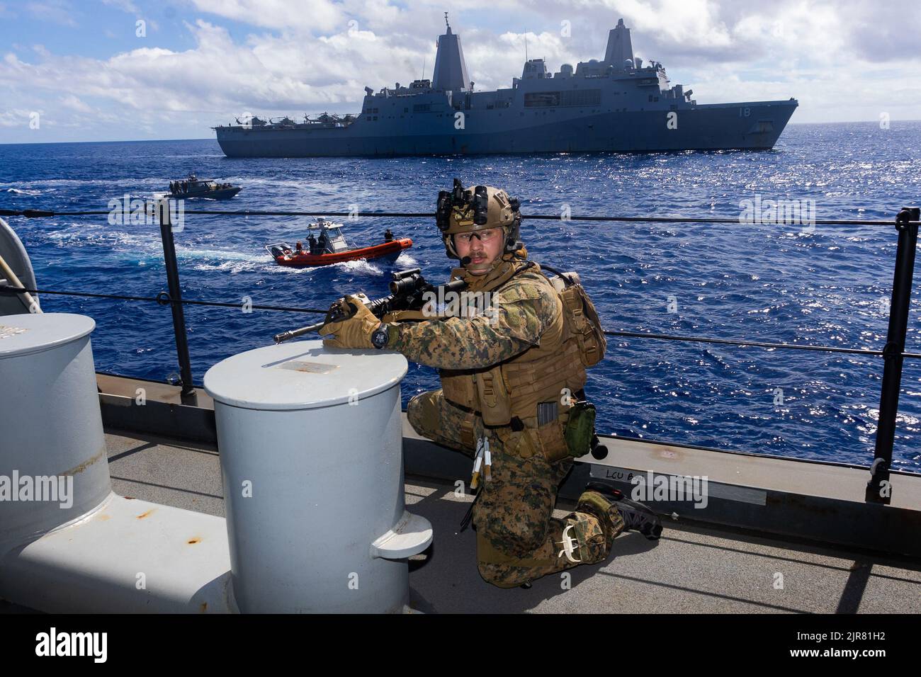 Una Marina di ricognizione degli Stati Uniti con Force Reconnaissance Platoon, 3rd Divisione Marina, 31st Marine Expeditionary Unit, pubblica la sicurezza a bordo della base mobile Expeditionary USS Miguel Keith (ESB-5) mentre il team di sicurezza, con il Battalion Landing Team 2/5, con 31st MEU, si avvicina su scafo rigido, Barche gonfiabili durante una visita bordo di ricerca e sequestro esercizio nel Mare delle Filippine, 17 agosto 2022. Il 31st MEU mantiene la capacità di sequestrare e liberare navi in mare per proteggere se stessi e gli alleati nella regione dell'Indo-Pacifico. Il 31st MEU opera a bordo delle navi del Tripoli Anfibio Ready Foto Stock