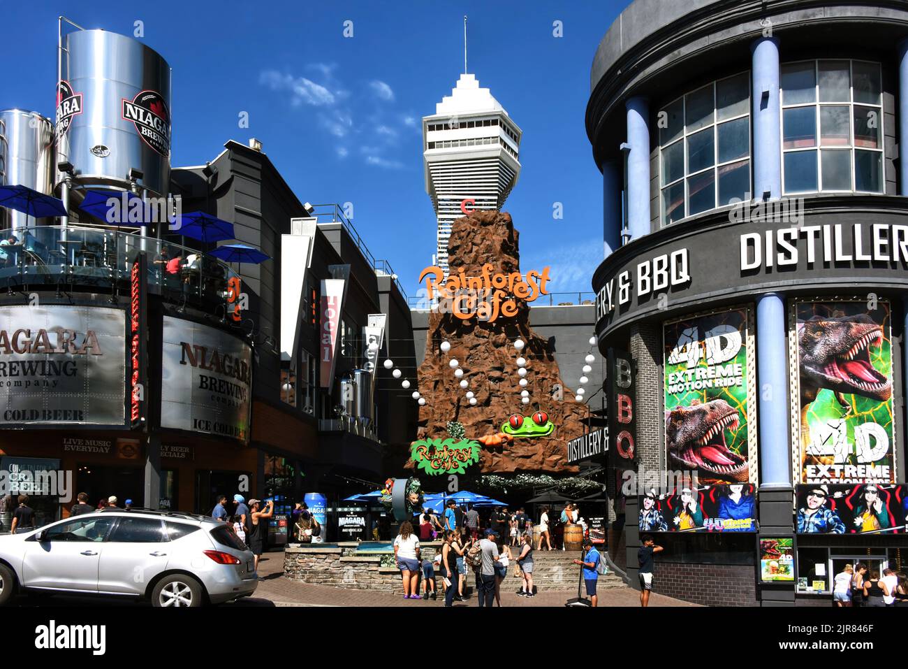 Cascate del Niagara, Canada - 13 agosto 2022: Rainforest Cafe e altre attrazioni turistiche sulla strada trafficata Clifton Hill. Casino Niagara torre può essere se Foto Stock