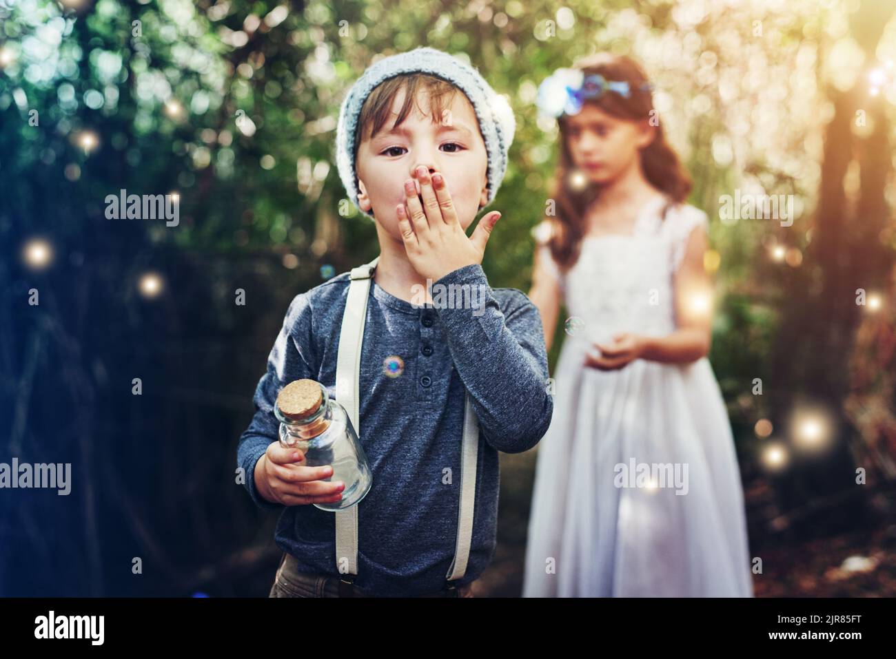 Abbiamo catturato tante fate. Ritratto di due piccoli fratelli che catturano lucciole in vasi all'esterno. Foto Stock