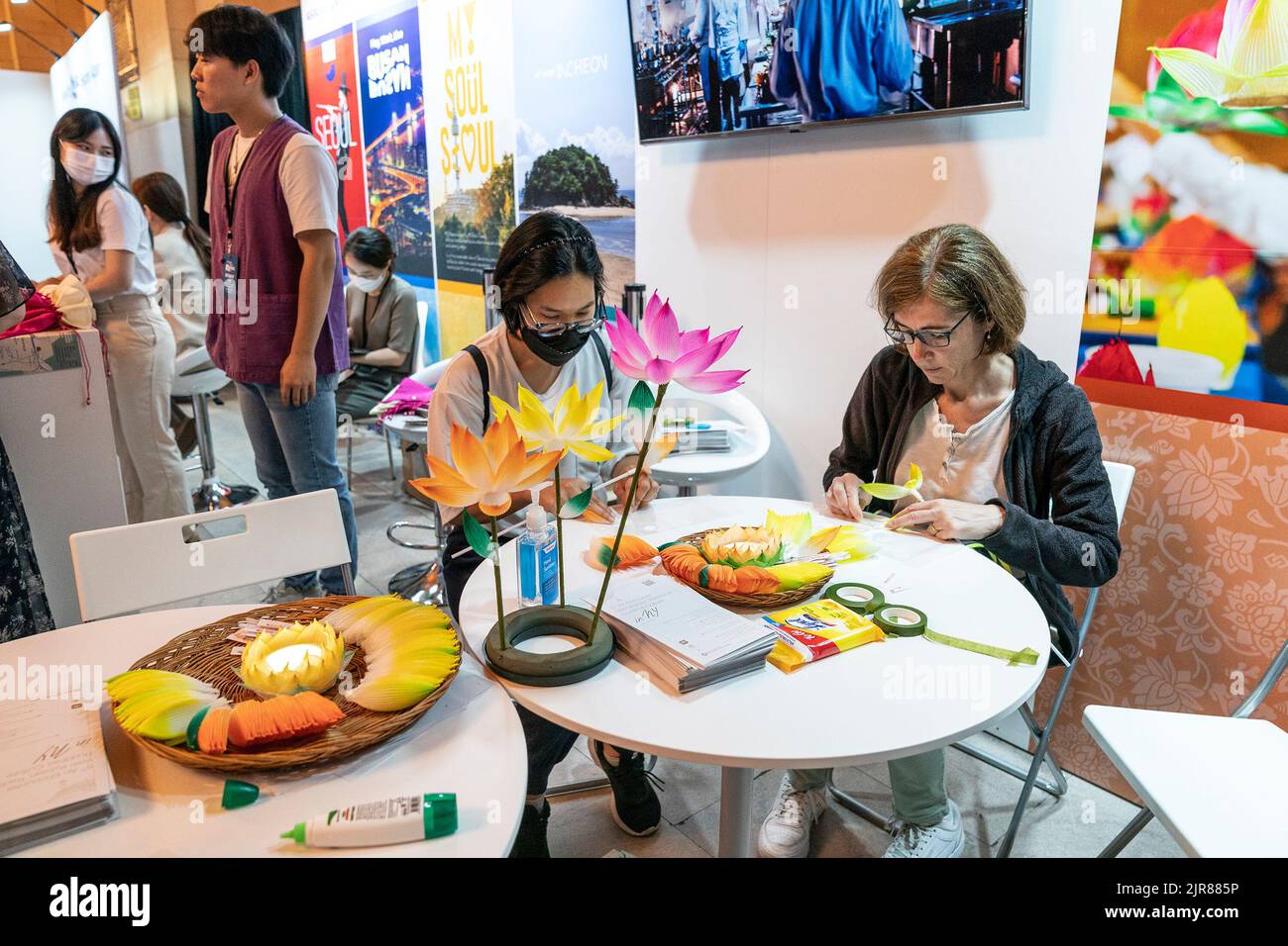 New York, Stati Uniti. 22nd ago, 2022. I visitatori imparano a fare fiori di carta durante la Corea Tourism Organization hosting 2022 Scopri la tua Corea alla Vanderbilt Hall del Grand Central Terminal. Ai visitatori è stato offerto di assaggiare il cibo tradizionale coreano e il cibo preparato per i templi buddisti, scoprire le bande K-Pop, i film coreani, fare fiori di carta, provare cosmetici coreani, costumi tradizionali e molto altro durante l'evento promozionale di 2 giorni. (Foto di Lev Radin/Pacific Press) Credit: Pacific Press Media Production Corp./Alamy Live News Foto Stock