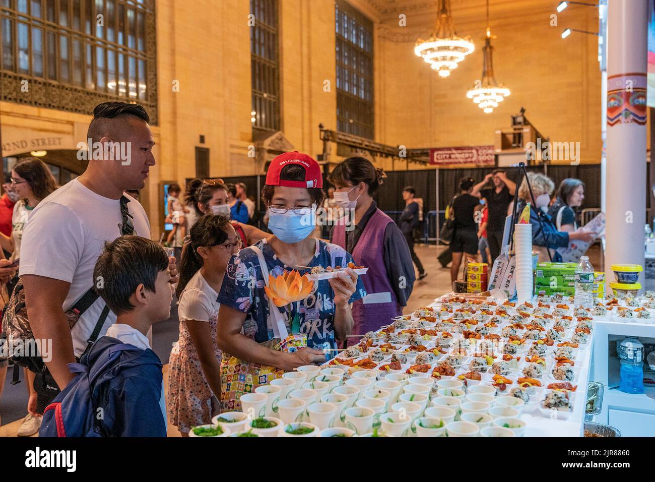 New York, Stati Uniti. 22nd ago, 2022. I visitatori assaggiano assaggi di cibo tradizionale coreano durante la Korea Tourism Organization che ospita 2022 Scopri la tua Corea alla Vanderbilt Hall del Grand Central Terminal. Ai visitatori è stato offerto di assaggiare il cibo tradizionale coreano e il cibo preparato per i templi buddisti, scoprire le bande K-Pop, i film coreani, fare fiori di carta, provare cosmetici coreani, costumi tradizionali e molto altro durante l'evento promozionale di 2 giorni. (Foto di Lev Radin/Pacific Press) Credit: Pacific Press Media Production Corp./Alamy Live News Foto Stock