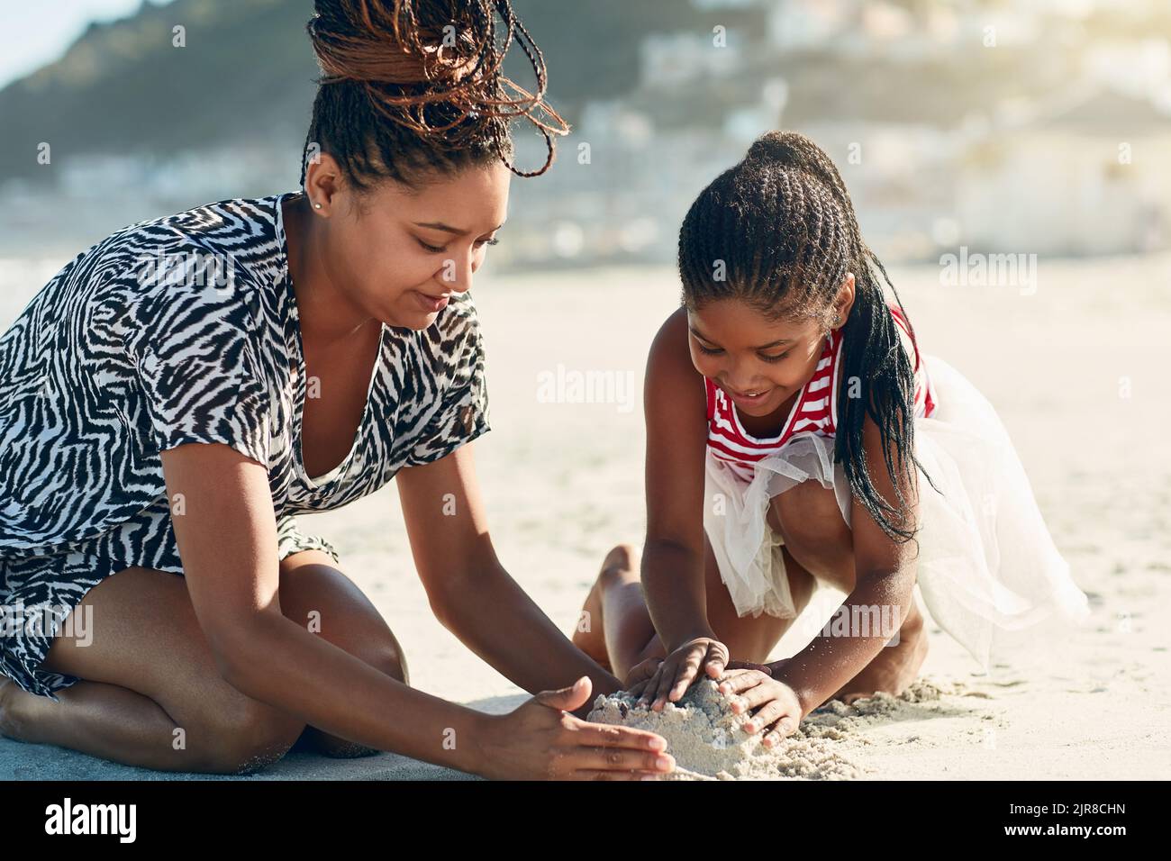 La creatività dei bambini prospera in un gioco aperto, come la costruzione di castelli di sabbia. Una madre e sua figlia costruiscono un castello di sabbia insieme al Foto Stock