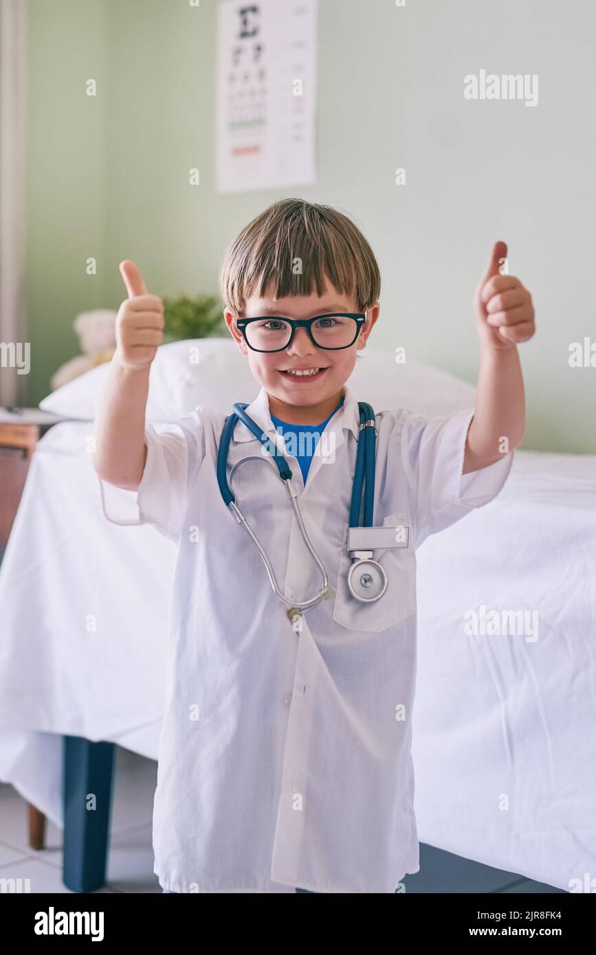 Vedo i medici come modelli di ruolo, un adorabile ragazzino vestito da medico. Foto Stock