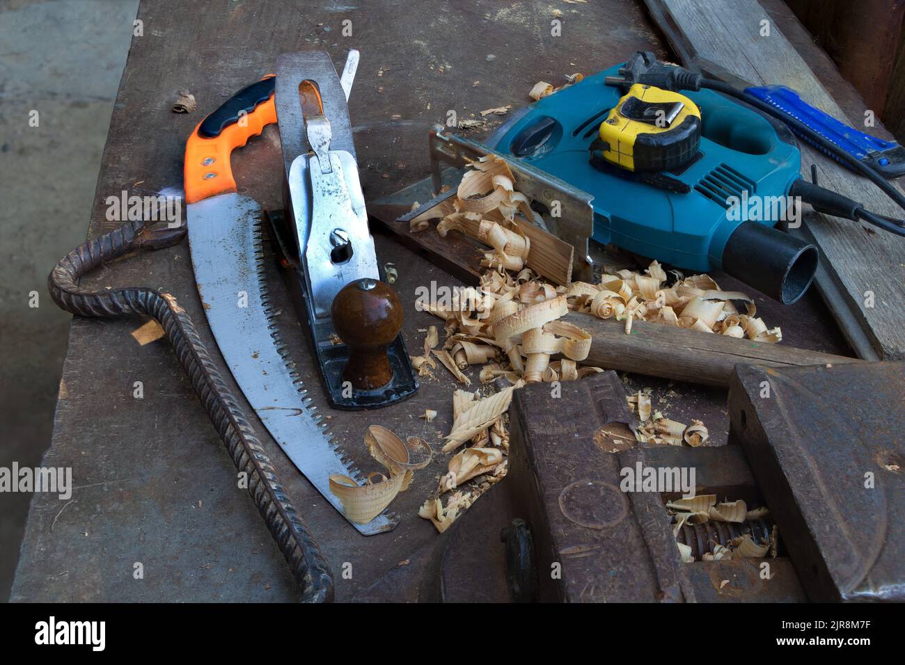 Un set di utensili utili nella costruzione per la lavorazione del legno come seghetto - sega - utensile piano - utensile di montaggio e misuratore sullo spazio di lavoro del metallo Foto Stock