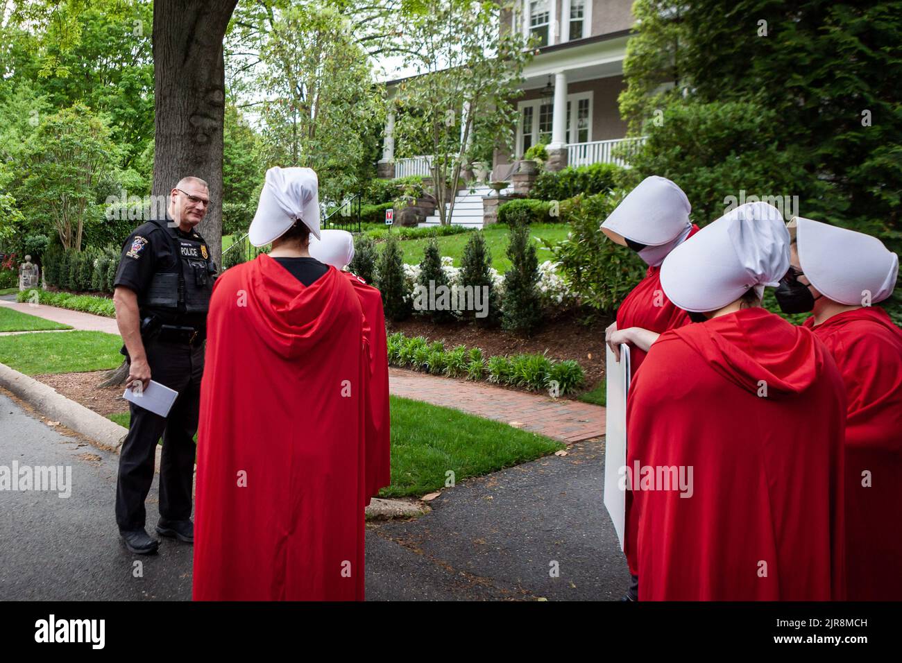 Washington, Stati Uniti. 12th maggio, 2022. Un poliziotto di Chevy Chase Village parla con i dimostranti vestiti come le manigelle dalla storia della cameriera prima che camminino verso il circolo sportivo di Chevy Chase per richiedere una domanda. Giustizia della Corte Suprema Brett Kavanaugh è un membro del Club, e secondo quanto riferito ha pagato una tassa di apertura di $$92.000 per aderire. L'esercito delle cordie DC giunse a Capitol Hill per protestare contro la decisione preliminare trapelata dalla Corte Suprema di ribaltare Roe contro Wade. (Credit Image: © Allison Bailey/SOPA Images via ZUMA Press Wire) Foto Stock