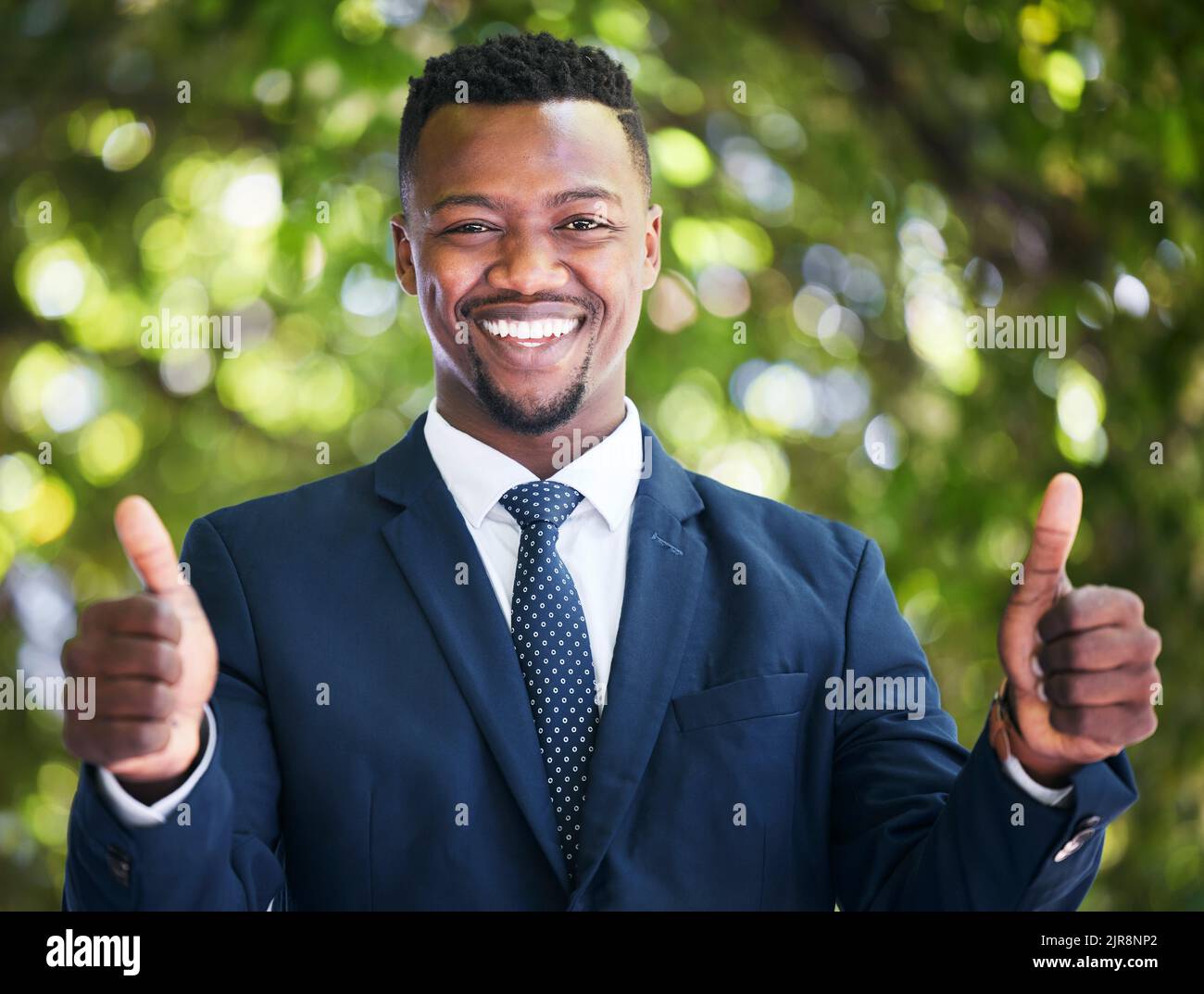 Thumbs in su, successo e uomo d'affari felice, soddisfatto ed eccitato circa l'occasione o l'obiettivo di lavoro. Ritratto di un imprenditore nero sentirsi come un vincitore Foto Stock
