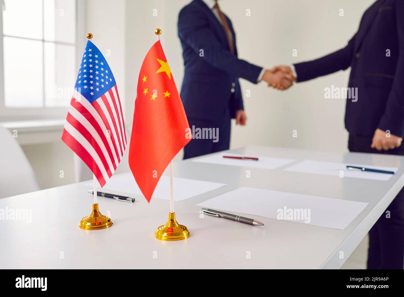 Bandiere politiche di Cina e Stati Uniti d'America sul tavolo vicino a mans in cause aziendali Foto Stock