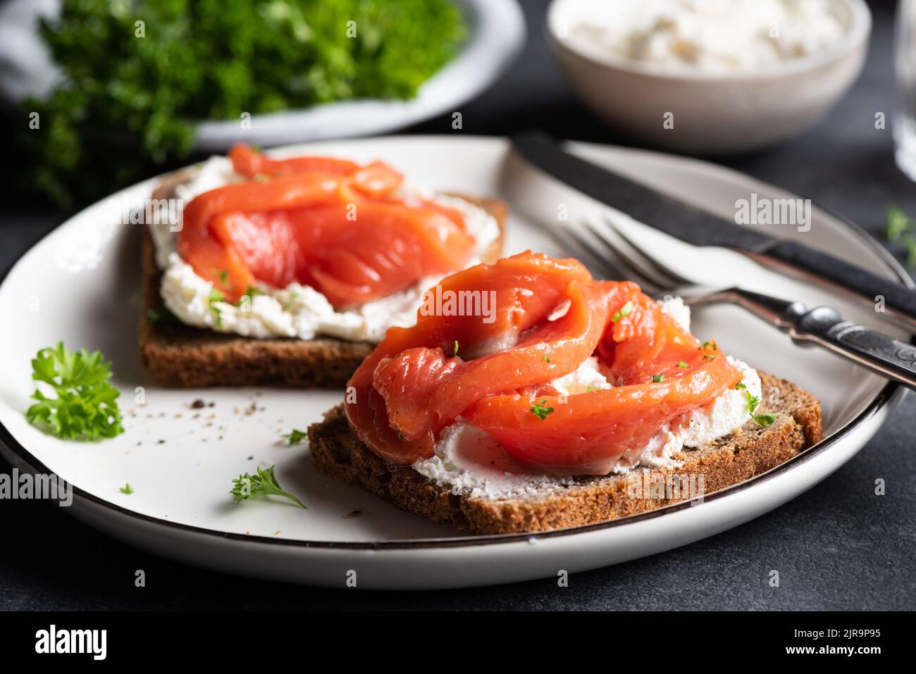 Panino di pane di segale con salmone e formaggio cremoso, vista in primo piano Foto Stock