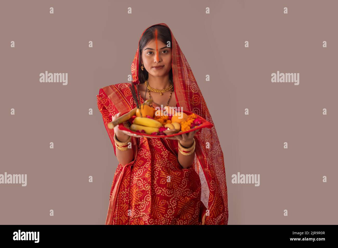 Donna di Bihar offre preghiere al sole nelle prime ore del mattino durante il Chhath Puja festival Foto Stock