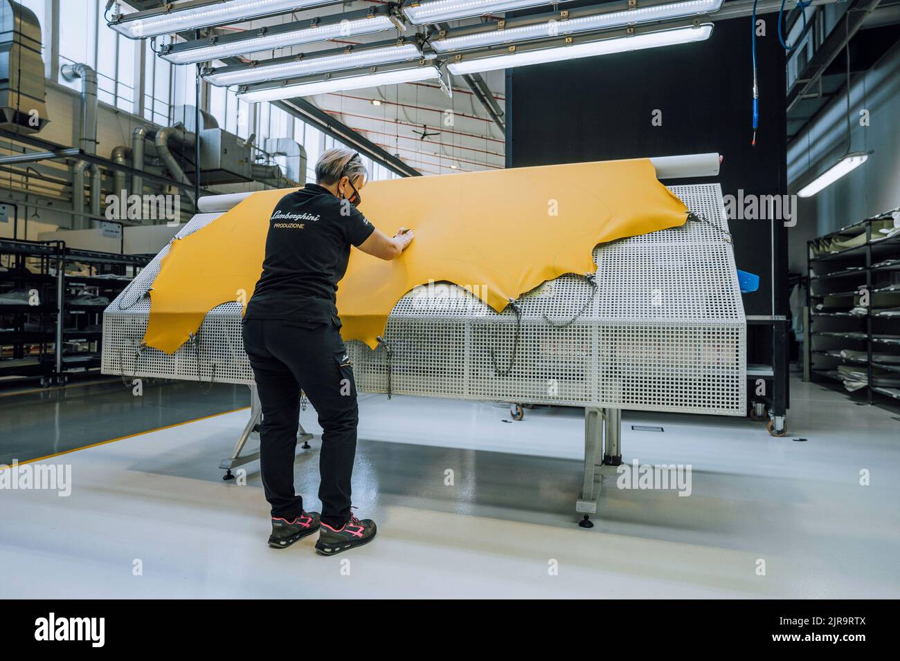 Italia, SantAgata Bolognese, 20 gennaio 2022: Stabilimento automobili Lamborghini. Donna e pezzi di pelle nel laboratorio di tappezzeria Foto Stock