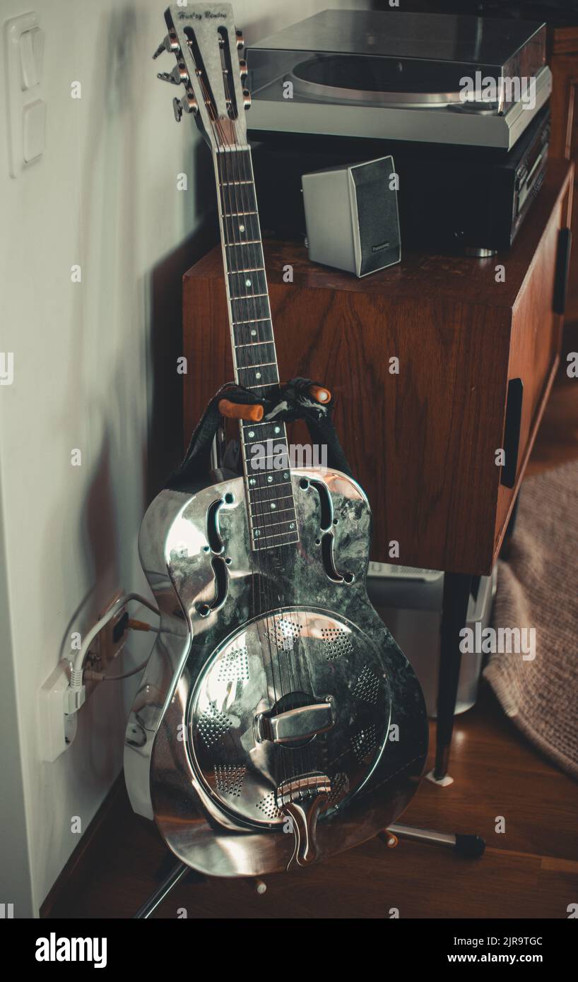 Una foto verticale di una chitarra d'argento e di un discensore Foto Stock