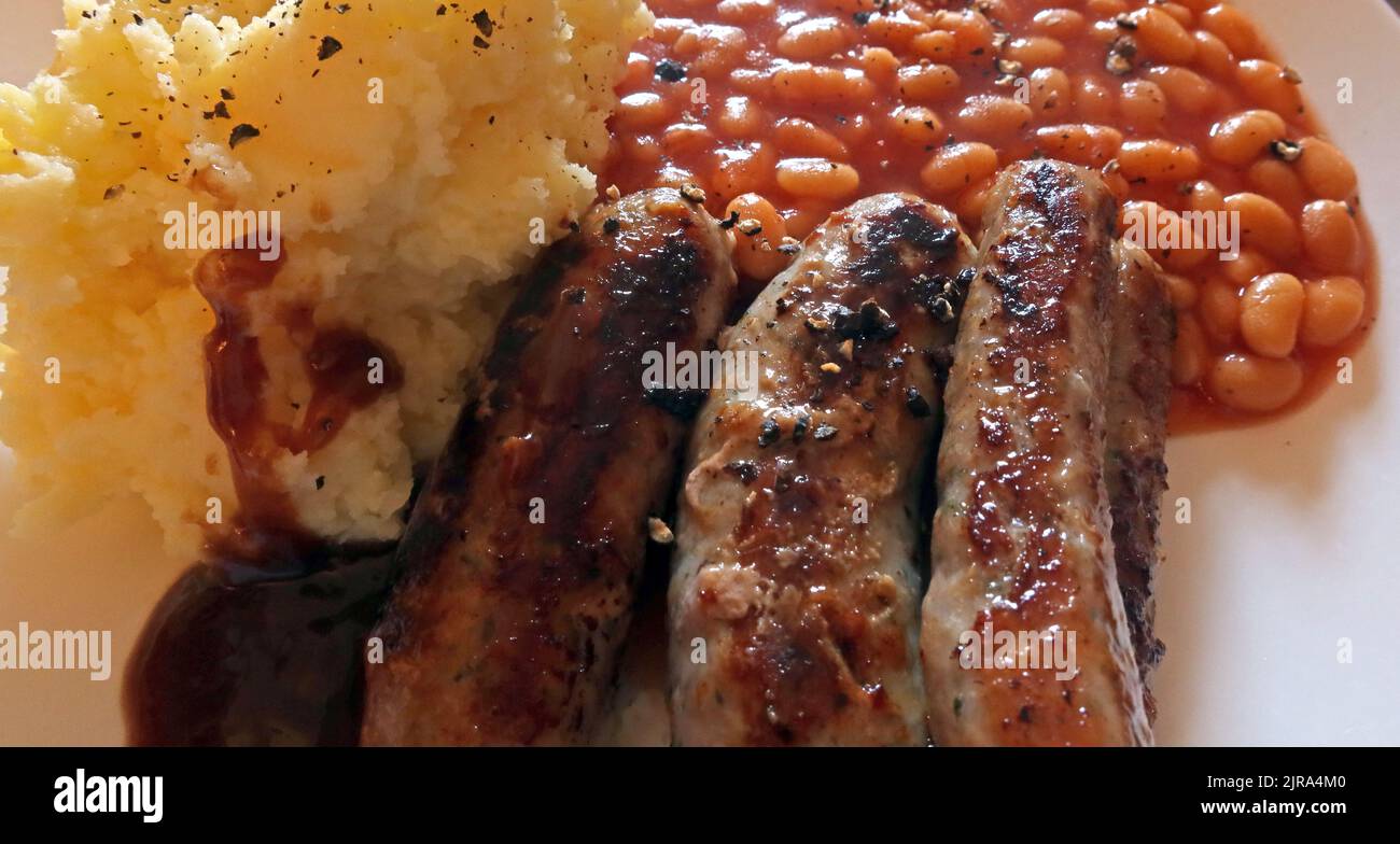 Salsiccia schiacciata e fagioli cotti su un piatto Foto Stock