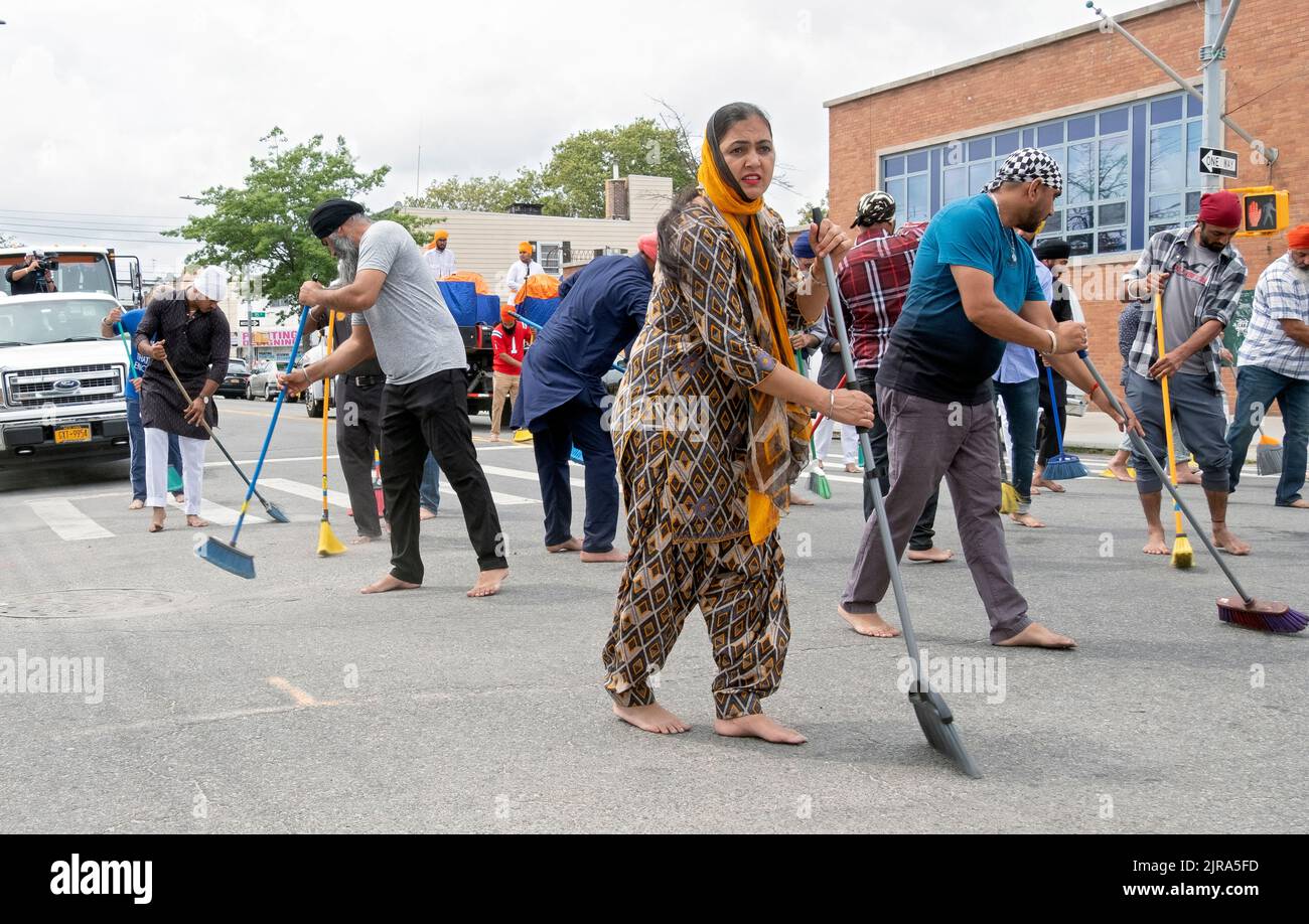 Devout Sikh uomini e donne spazzare 101st Avenue dove una parata galleggiante portare il loro libro santo, Guru Granth Sahib, passerà. Alla Parata Nagar Kirtan. Foto Stock