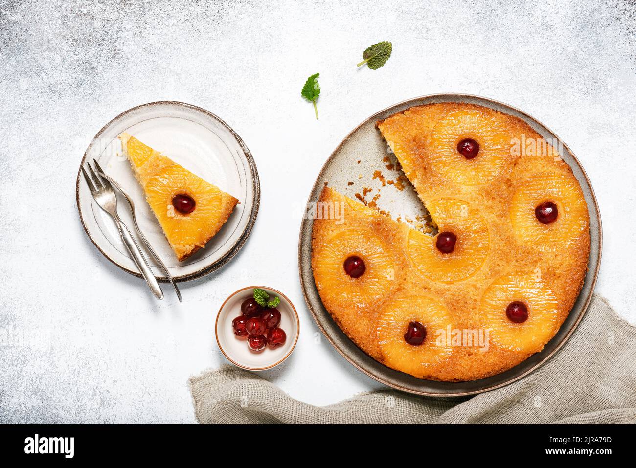 Torta di ananas capovolta tagliata a fette con ciliegie candite e caramello. Dessert tropicale estivo. Vista dall'alto. Foto Stock
