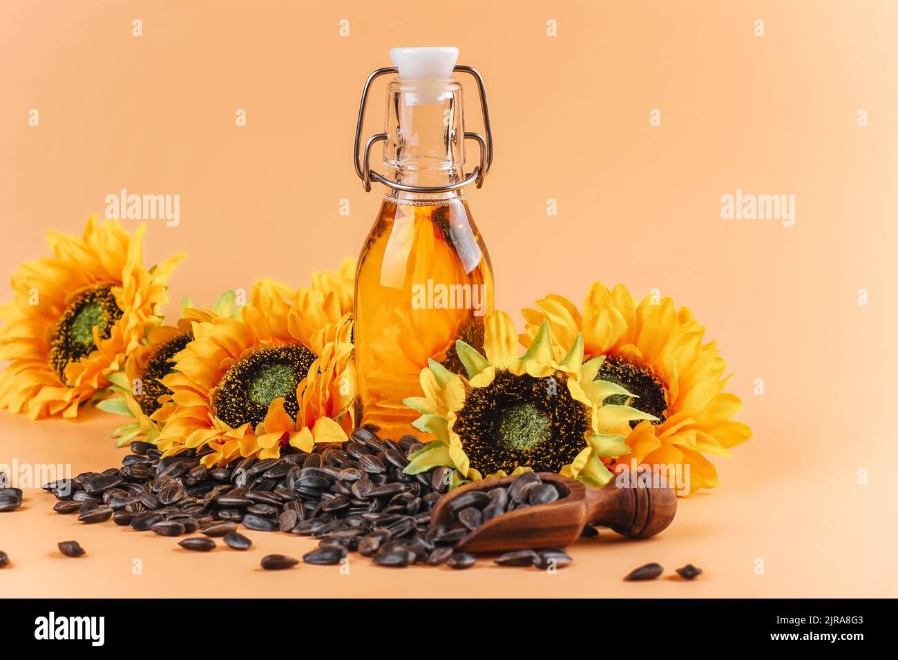 Olio di girasole dorato e non raffinato, semi di girasole e fiori su sfondo estivo. Spazio di copia Foto Stock