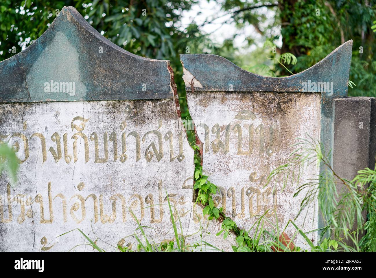 Un muro incrinato, con scritta thailandese su di esso, preso a Buriram, Thailandia. Foto Stock