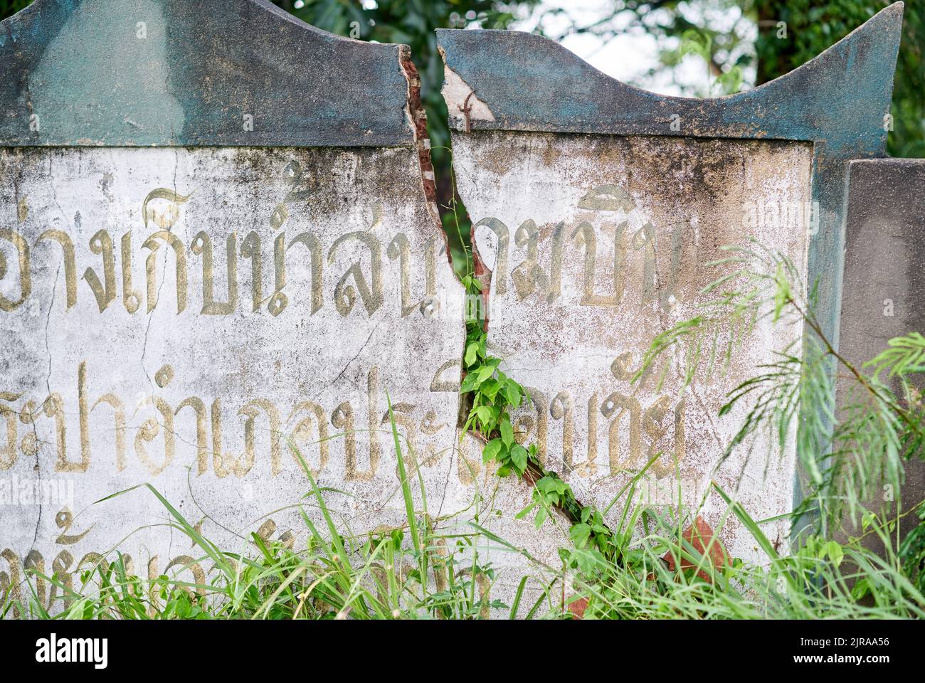 Un muro incrinato, con scritta thailandese su di esso, preso a Buriram, Thailandia. Foto Stock