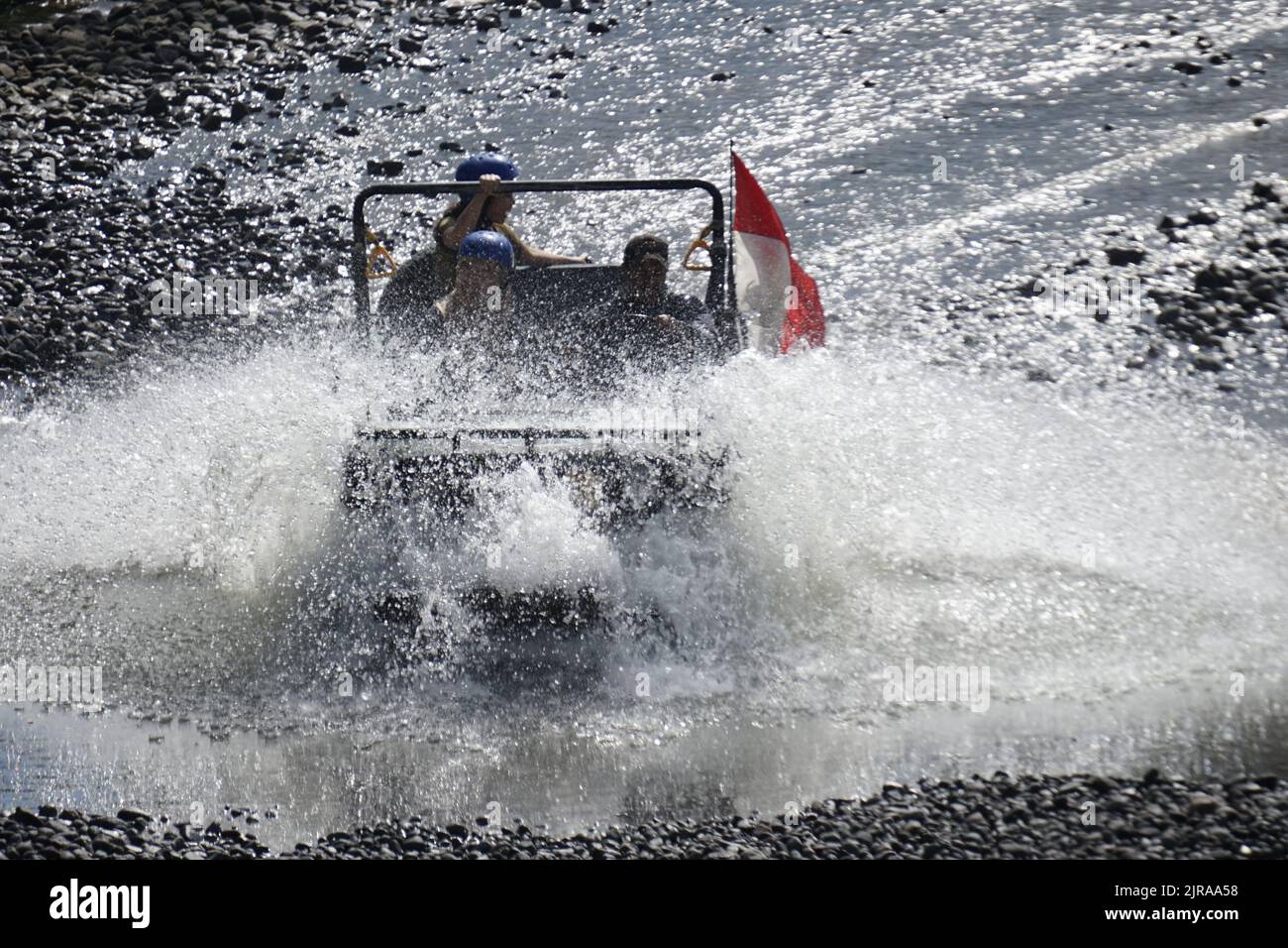 L'auto fuoristrada porta i turisti che attraversano il fiume Kalikuning a Sleman, Yogyakarta, Indonesia. Questo 'tour lavico' e' uno dei principali toursm di Yogyakarta Foto Stock