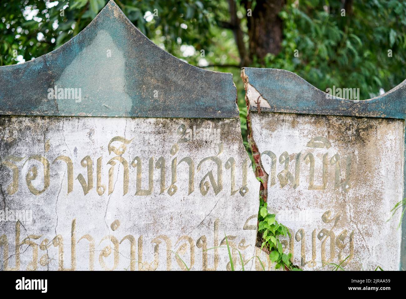 Un muro incrinato, con scritta thailandese su di esso, preso a Buriram, Thailandia. Foto Stock