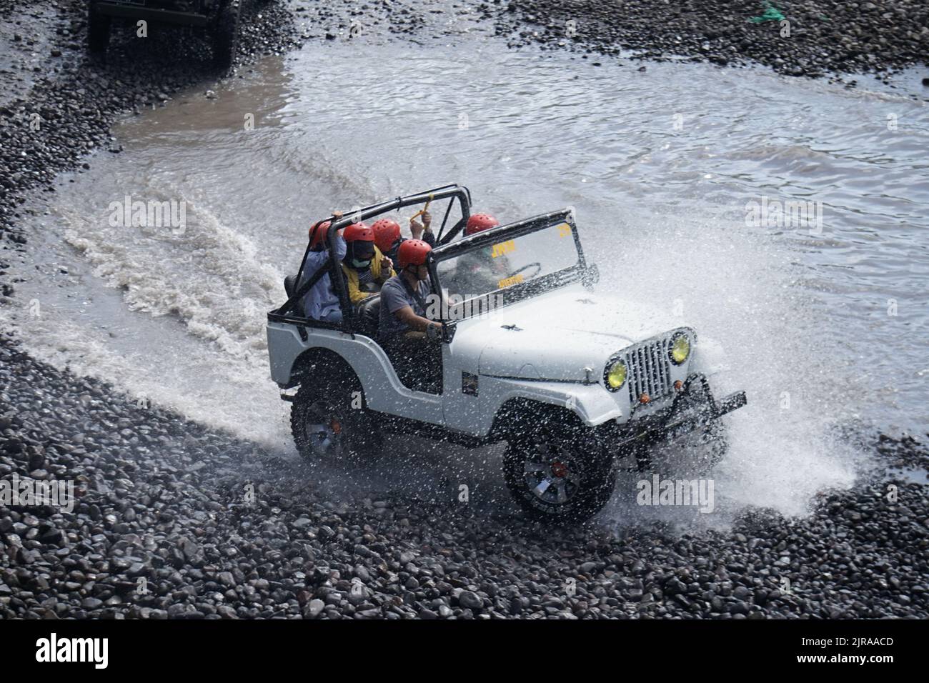 L'auto fuoristrada porta i turisti che attraversano il fiume Kalikuning a Sleman, Yogyakarta, Indonesia. Questo 'tour lavico' e' uno dei principali toursm di Yogyakarta Foto Stock