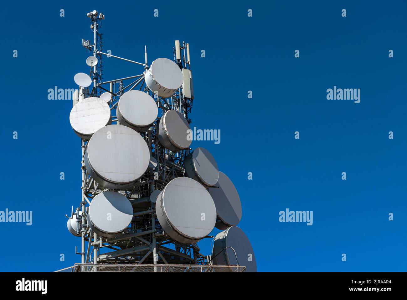 Tecnologia di comunicazione con antenna su cielo blu con spazio di copia. La torre di comunicazione si collega ai dati della città intelligente. Telecomunicazioni via satellite 5G. Foto Stock
