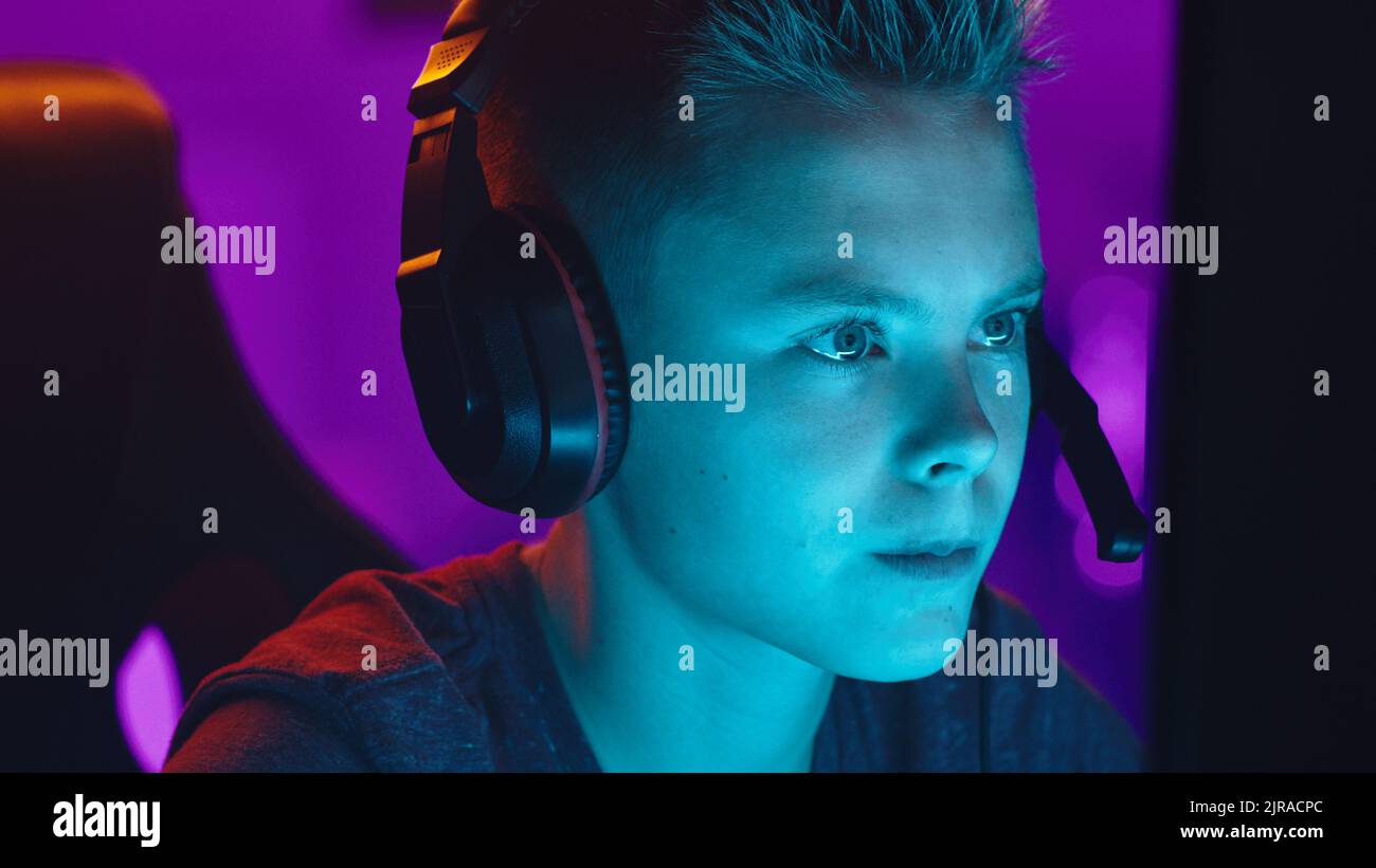 Teen gamer esprimere disprezzo mentre si discute di partita di videogame con i compagni di squadra di notte a casa Foto Stock