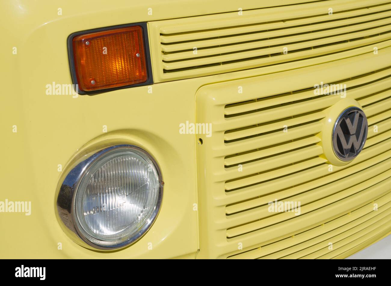 T2 VW Camper van in giallo brillante dettaglio primo piano in pieno sole del faro e badge Foto Stock