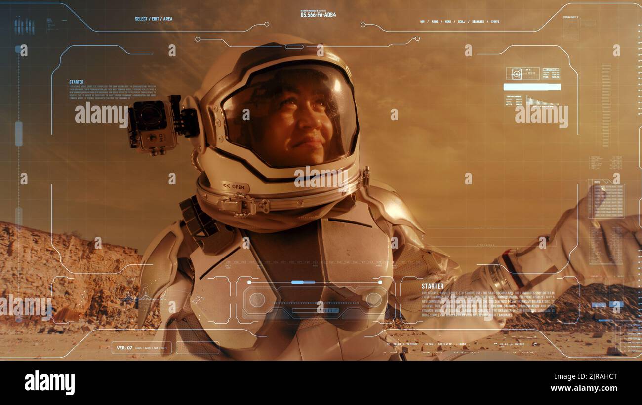Donna nello spazio vestito agitando la mano e gestendo il pollice in su mentre parla della vita su Marte per la registrazione del diario video con l'interfaccia blu Foto Stock
