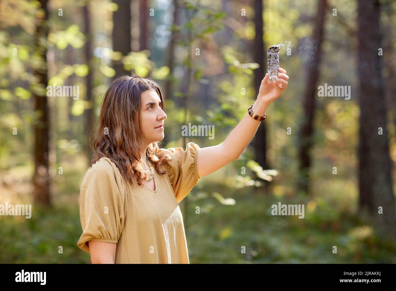 donna o strega che esegue rituale magico nella foresta Foto Stock