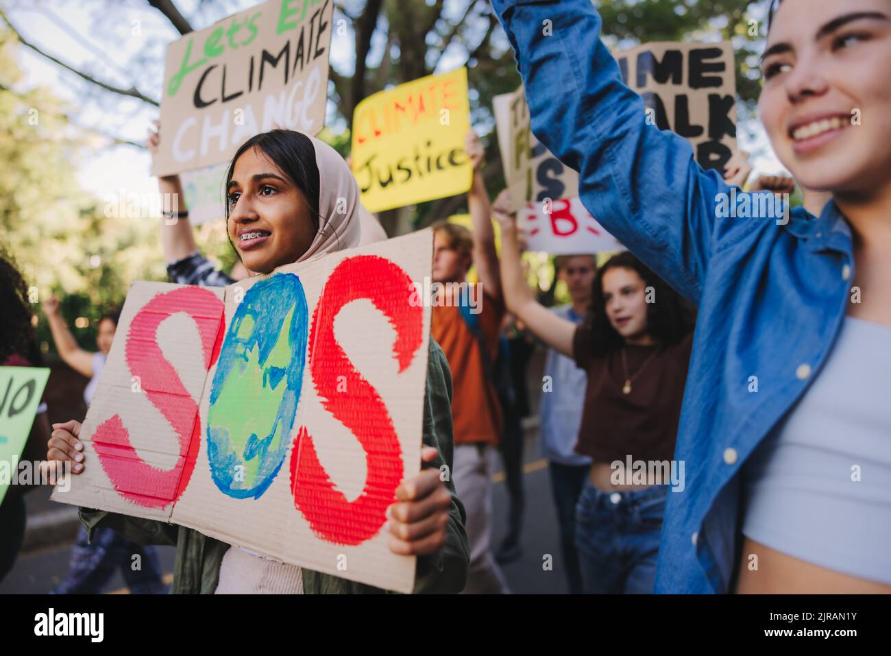 Salva la nostra campagna specie. Gruppo di attivisti giovanili multiculturali che trasportano manifesti mentre marciano contro il riscaldamento globale e il cambiamento climatico. Diverso y Foto Stock