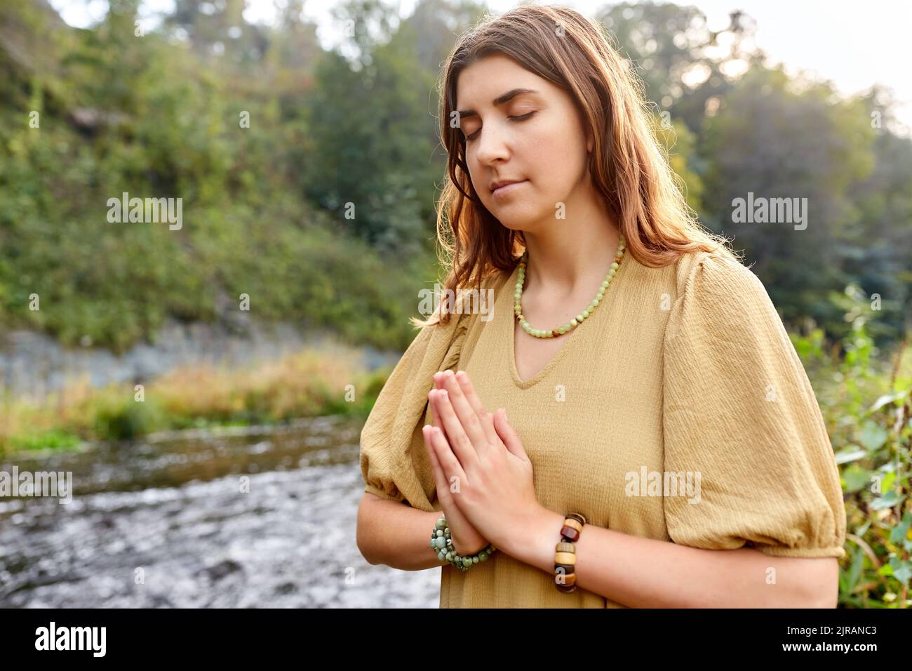 donna o strega che esegue rituale magico sul fiume Foto Stock
