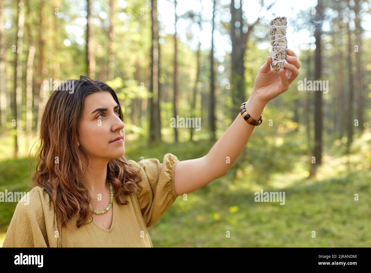 donna o strega che esegue rituale magico nella foresta Foto Stock