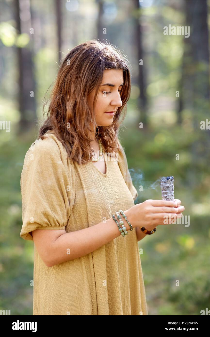 donna o strega che esegue rituale magico nella foresta Foto Stock