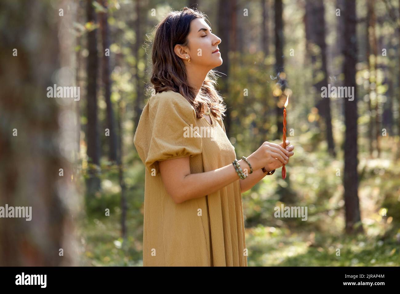 donna o strega che esegue rituale magico nella foresta Foto Stock