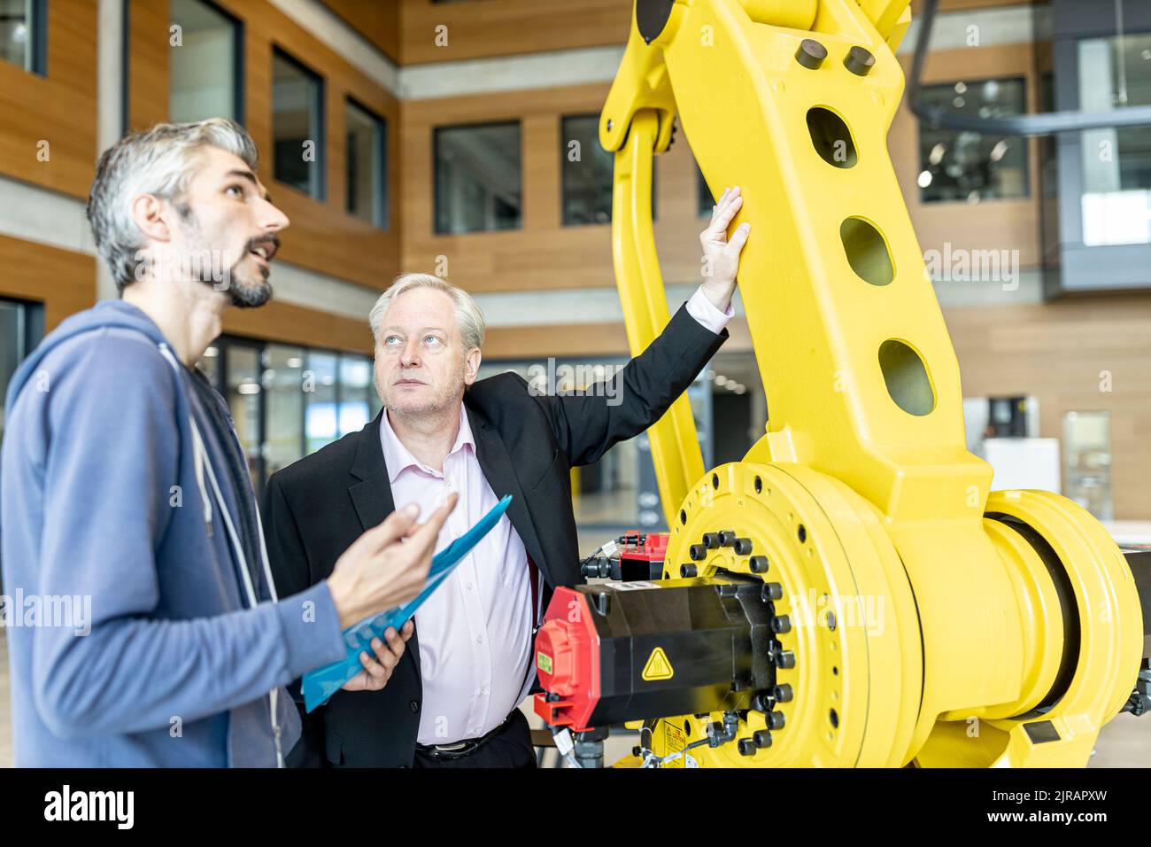 I clienti senior ricevono consigli sui robot industriali da personale esperto Foto Stock