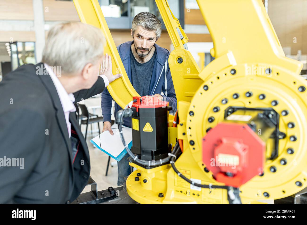 I clienti senior ricevono consigli sui robot industriali da personale esperto Foto Stock