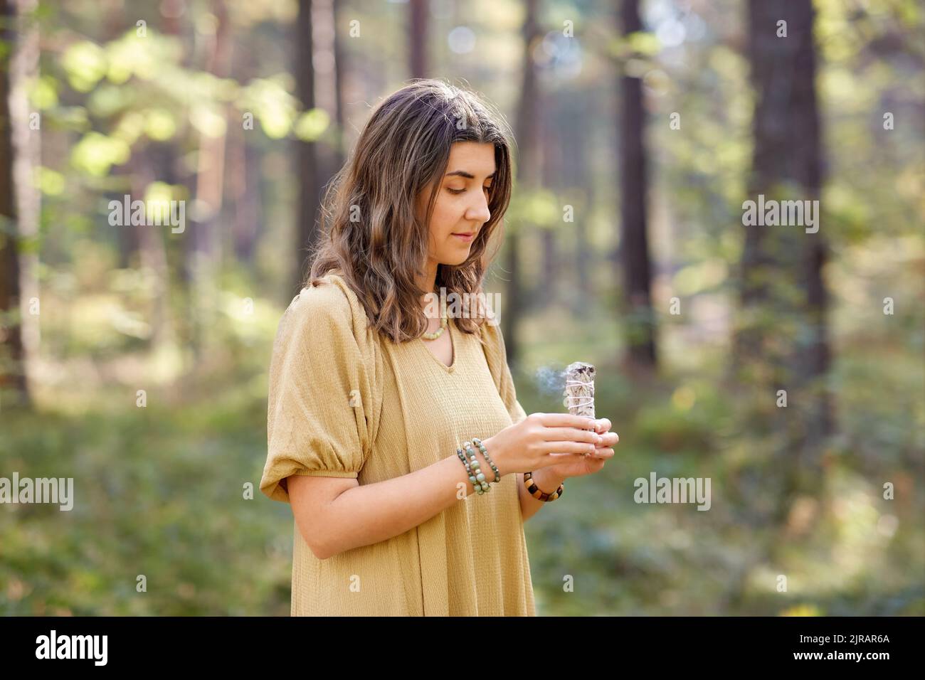 donna o strega che esegue rituale magico nella foresta Foto Stock