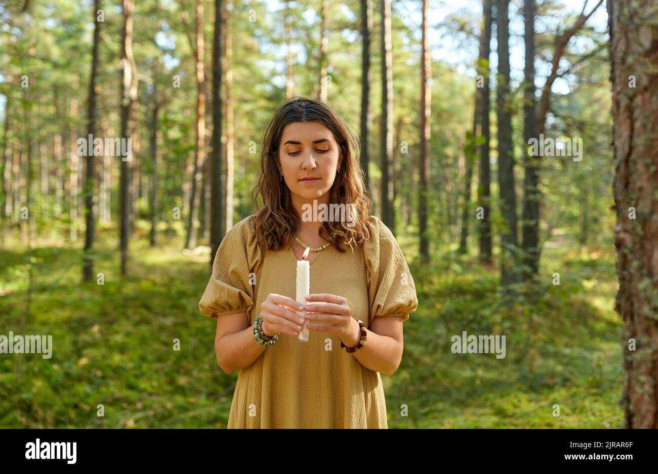 donna o strega che esegue rituale magico nella foresta Foto Stock