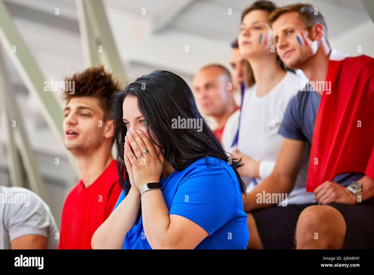 Donna con le mani che ricoprono la bocca esprimendo delusione per l'evento sportivo nello stadio Foto Stock