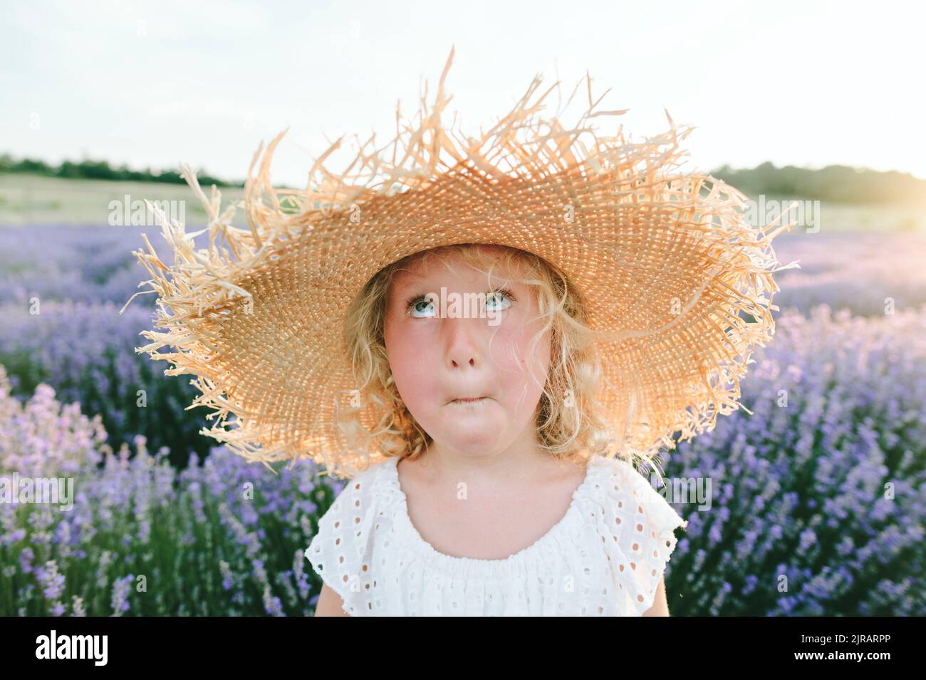 Ragazza che indossa cappello che fa faccia in campo di lavanda Foto Stock