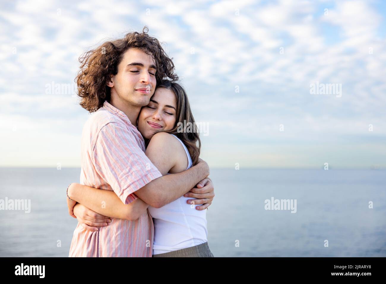 Felice giovane coppia con gli occhi chiusi abbracciandosi l'un l'altro Foto Stock