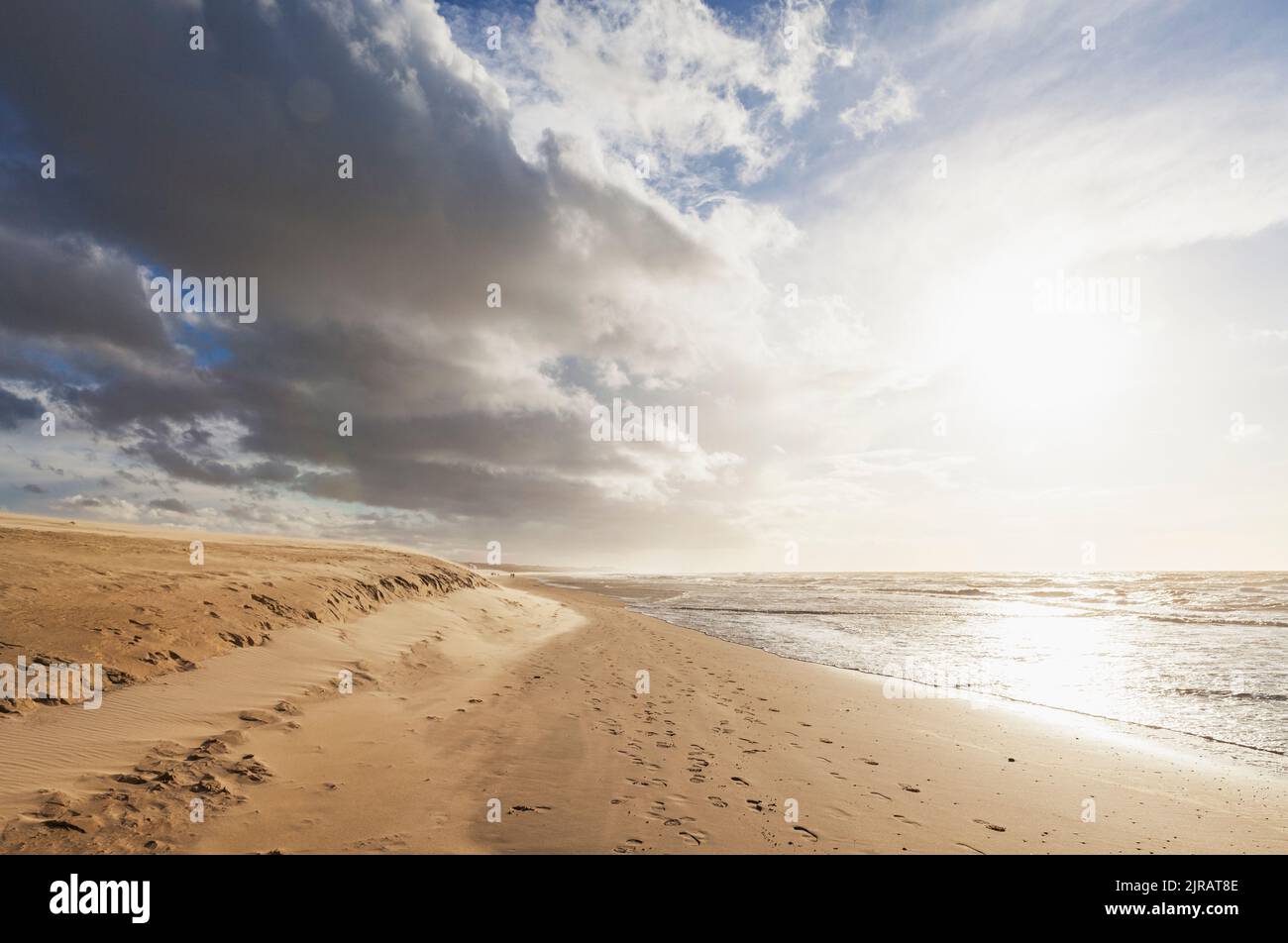 Nuvole sulla spiaggia di sabbia al tramonto Foto Stock