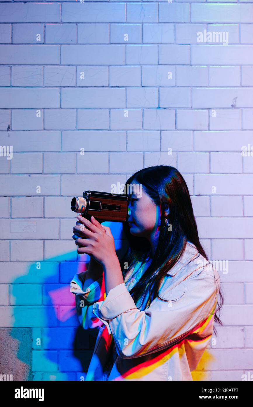 Giovane donna che filma con la videocamera di notte Foto Stock