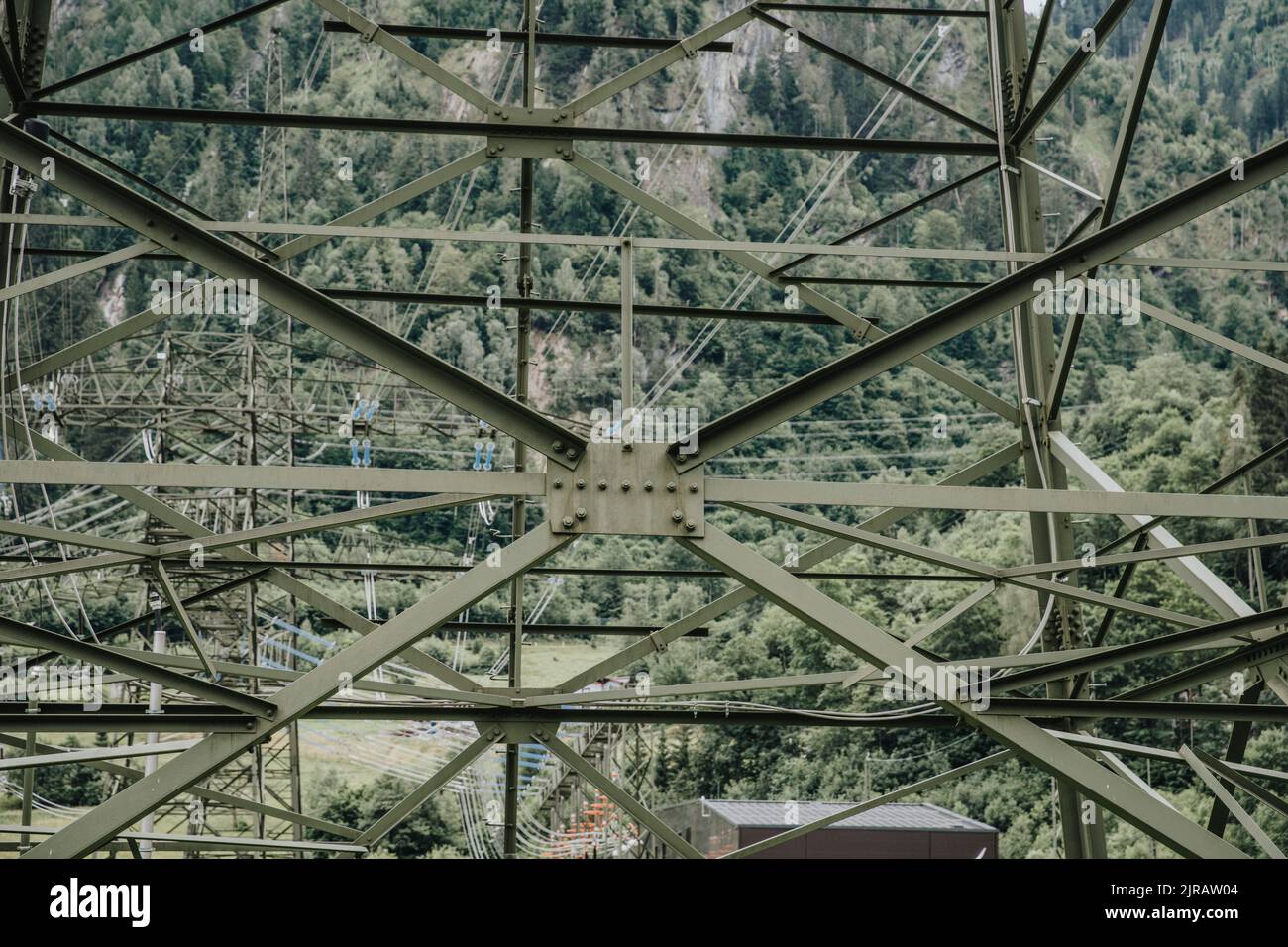 Struttura complessa di torre elettrica ad alta tensione di fronte agli alberi Foto Stock