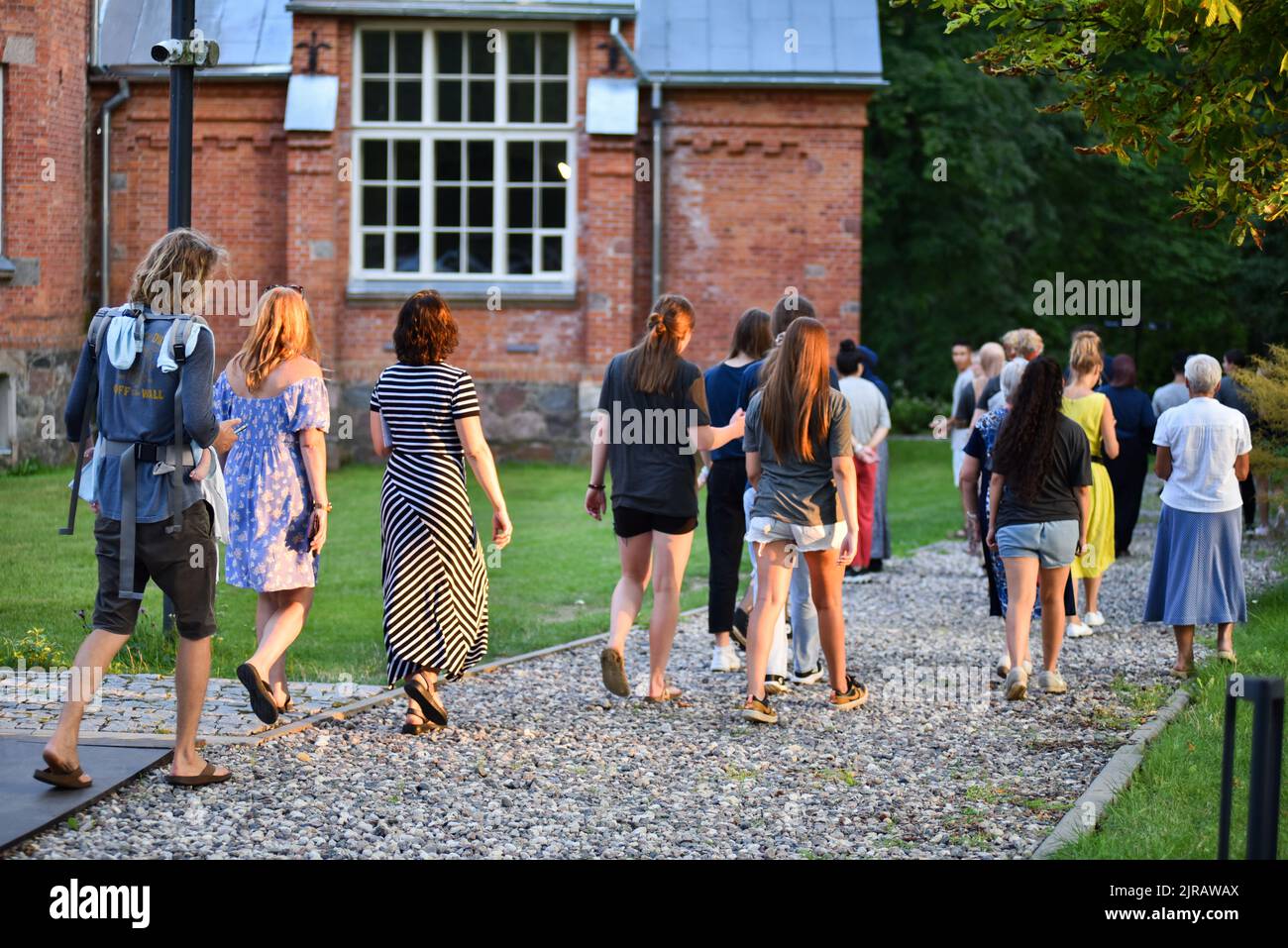 In serata, le persone camminano nel parco e ammirano le attrazioni locali. Foto Stock