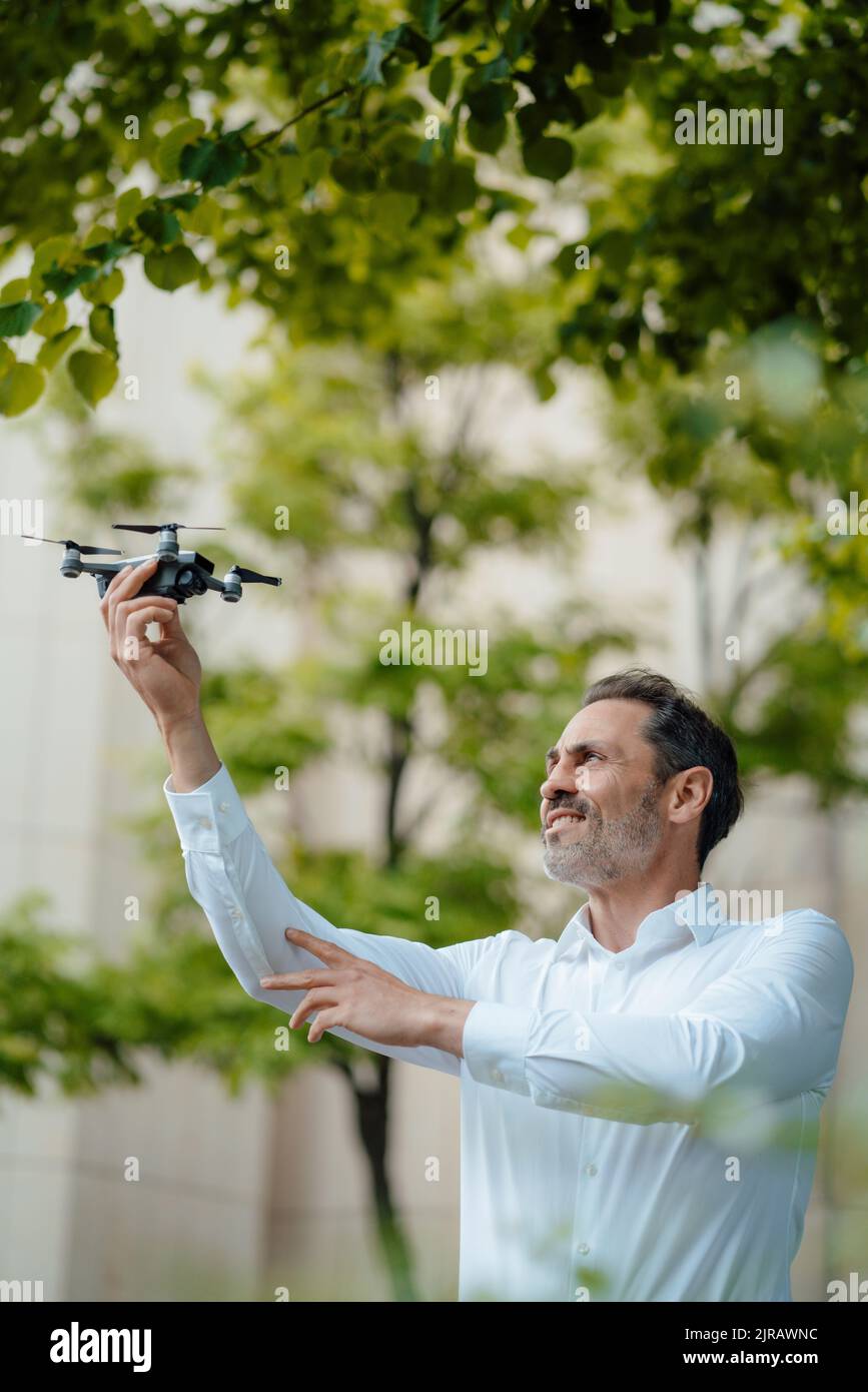 Uomo d'affari maturo che analizza drone Foto Stock