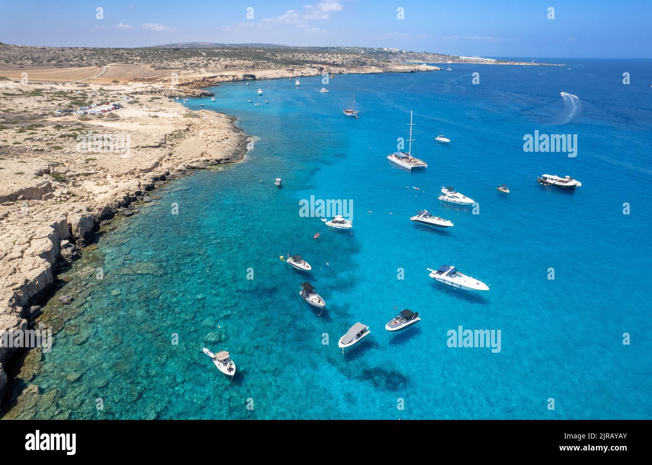Droni aerei marini yacht di lusso ormeggiati sulla costa e persone non riconosciute nuotare e rilassarsi. Vacanze estive al mare. Ayia Napa Cipro Foto Stock