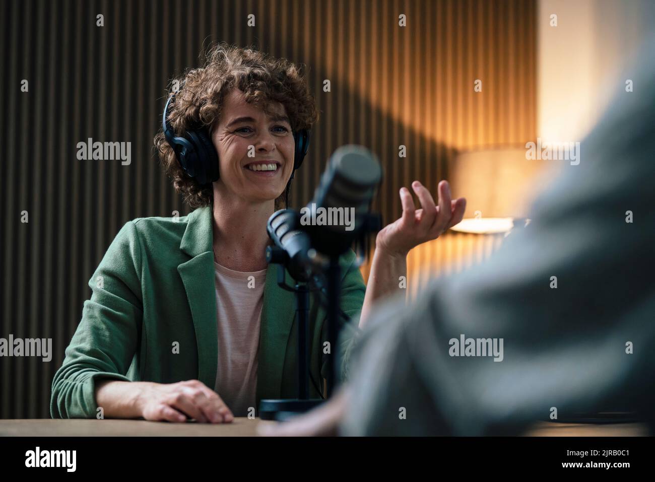 Presentatore felice che parla con l'ospite nella registrazione ospite Foto Stock