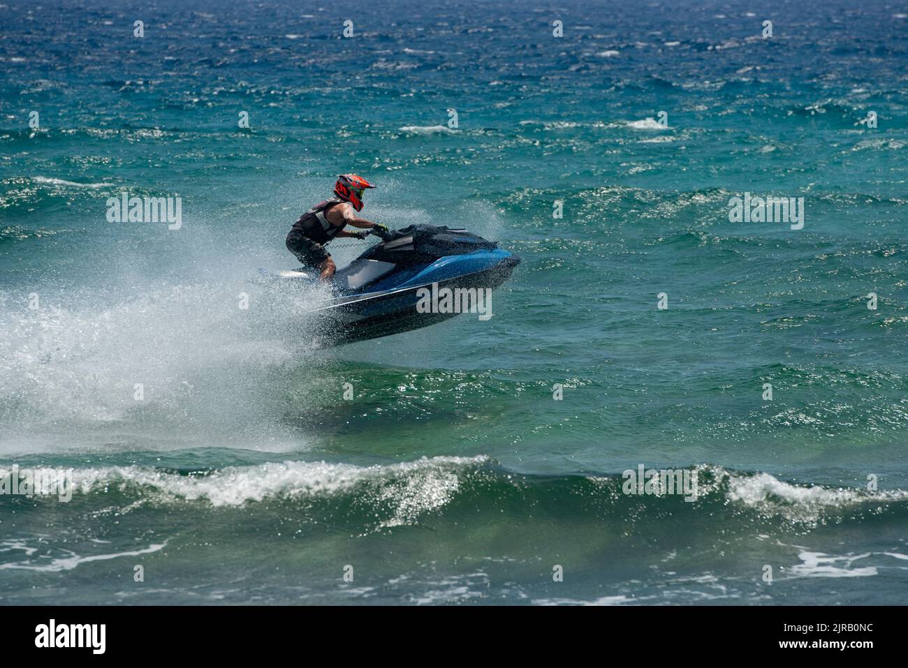 Uomo su scooter d'acqua, Jet ski contro le onde del mare Foto Stock